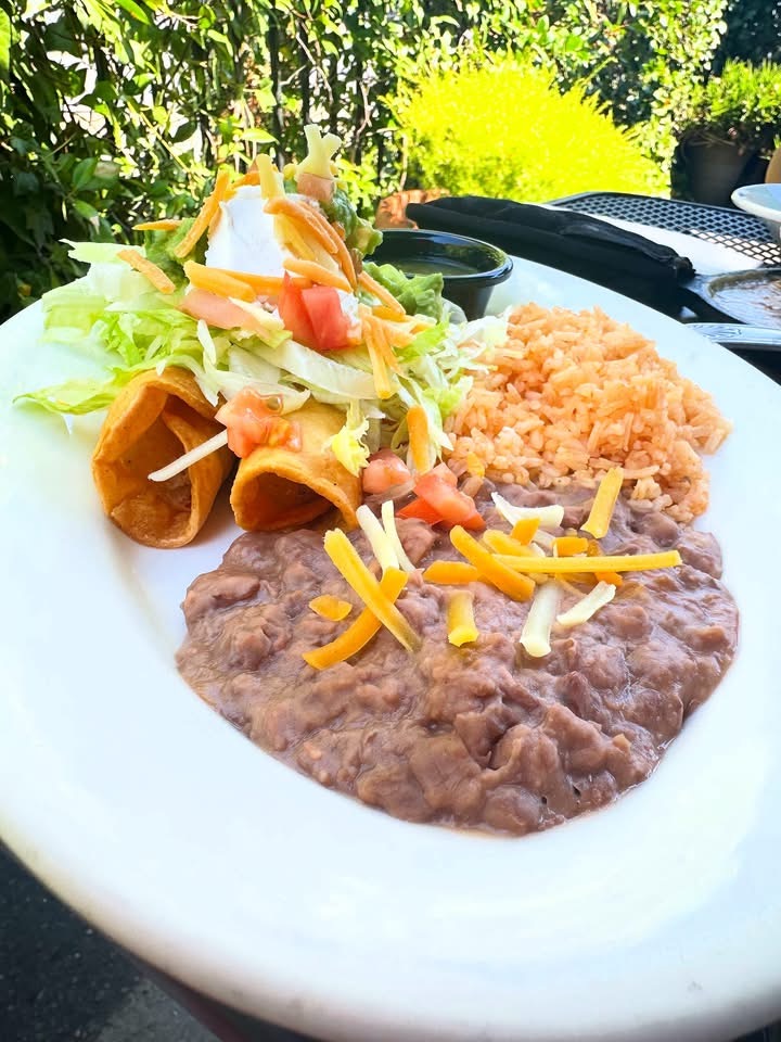 Vegan taquitos served with refried beans, Mexican rice, lettuce, tomato and shredded vegan cheese at Cocina Michoacana in Oakdale.