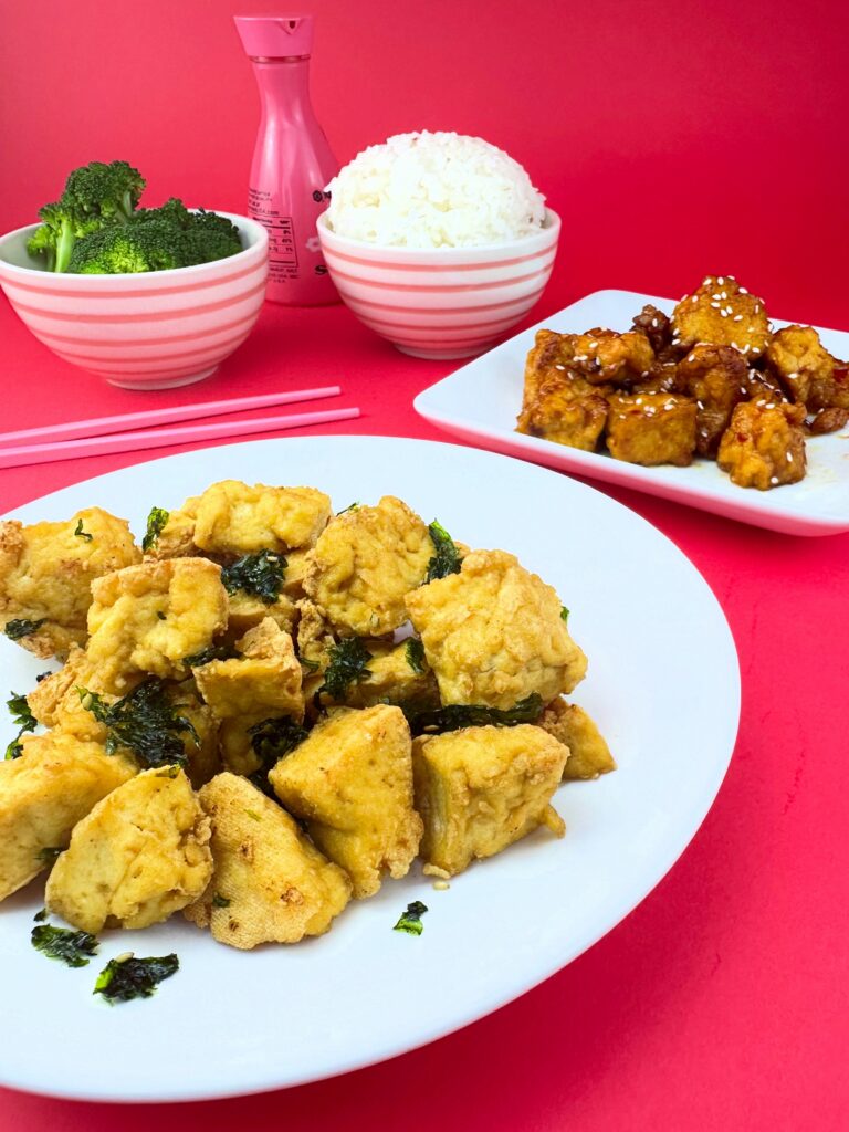 Blackbird Foods Original Crispy Tofu served on a white plate with rice, broccoli, and General Tso's Crispy Tofu in the background.