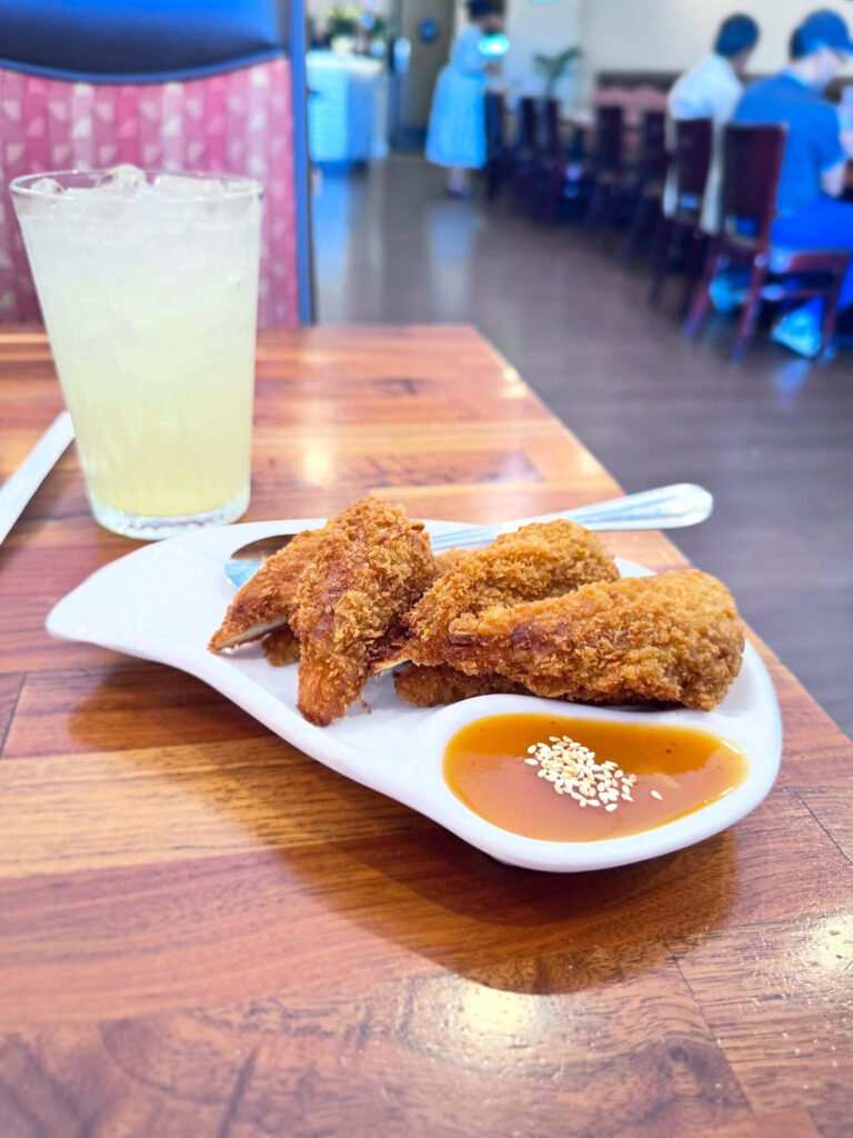 Plate of Blossom Vegan's signature vegan drumsticks served with plum dipping sauce alongside a refreshing lemonade.