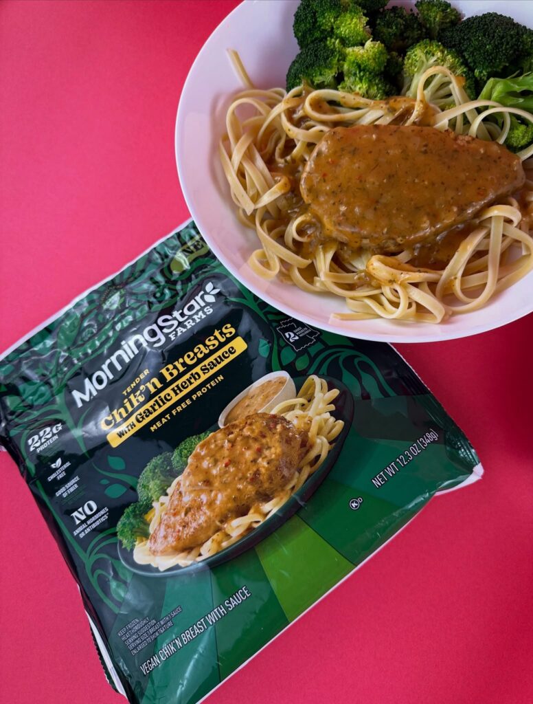 MorningStar Farms Chik'n Breast fillet served over linguine pasta with broccoli and garlic herb sauce beside the product package.