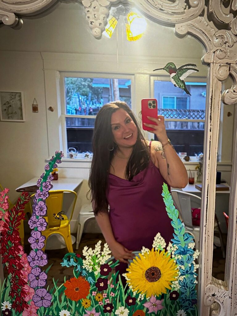 Tiffany of Your Neighborhood Vegan taking a mirror selfie inside Alchemist Café & Elixir Bar in Modesto.