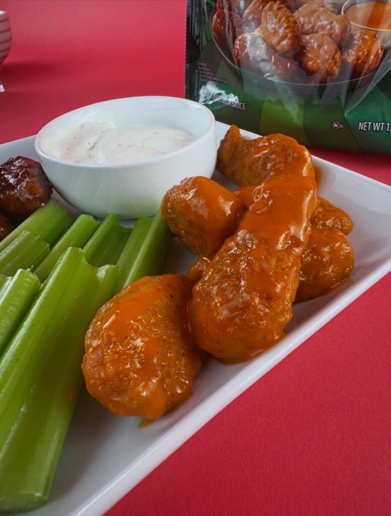 Close-up of MorningStar Farms Buffalo Chik'n Wings with celery sticks and vegan ranch dipping sauce.