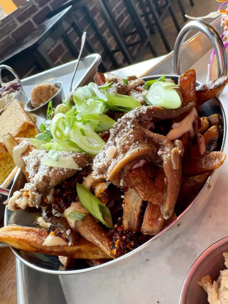 Loaded fries topped with Caesar salad fixings and oyster mushroom anchovies at Fungi Foods.