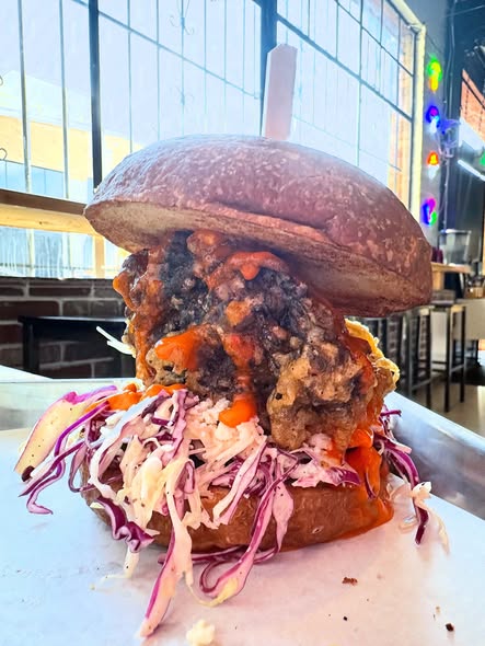 Vegan Buffalo Blue fried maitake mushroom sandwich with coleslaw on a purple bun at Fungi Foods in Oakland.