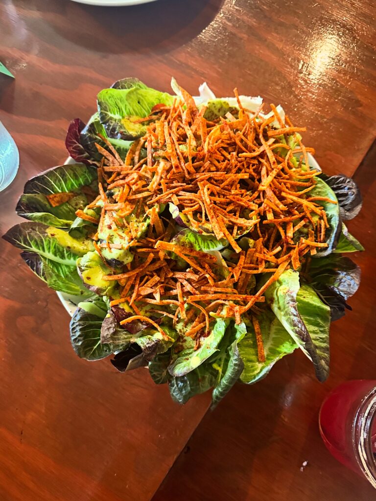 Sweet Gem Salad topped with charred corn, black beans and crispy tortilla strips at Cast Iron Trading Co.’s Vegan Roast.