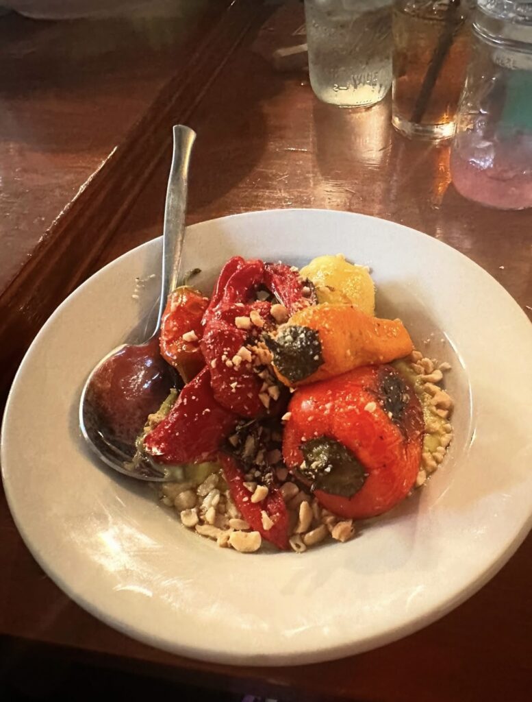 Charred Jimmy Nardello peppers served with avocado citrus Caesar vinaigrette, pepitas and cashews.