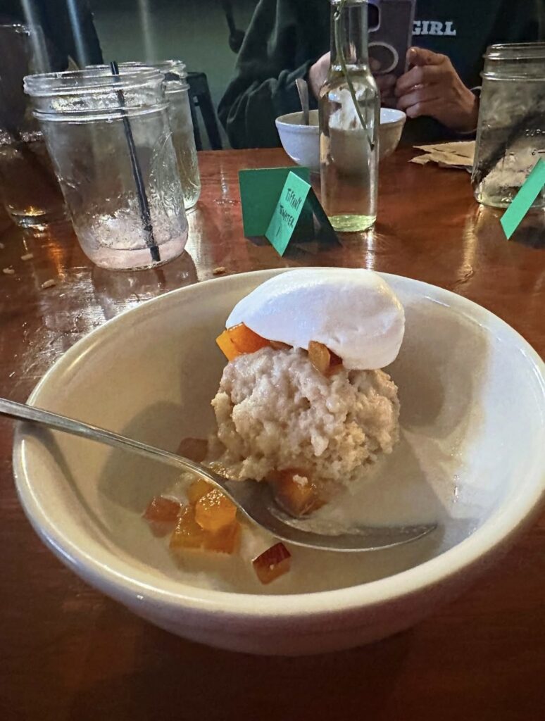 Vegan tres leches cake with fresh peaches, whipped coconut cream and tres leches sauce.