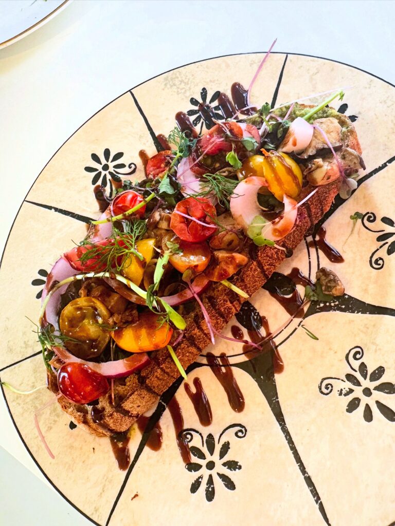 Sacred Toast with vegan pesto, sprouts, mushrooms, red onion and tomato at Alchemist Café in Modesto