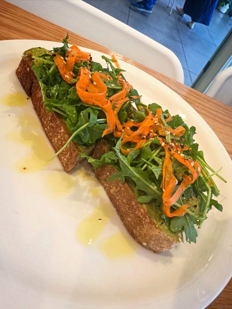 Vegan avocado toast with arugula and pickled carrots at Penny University Coffee