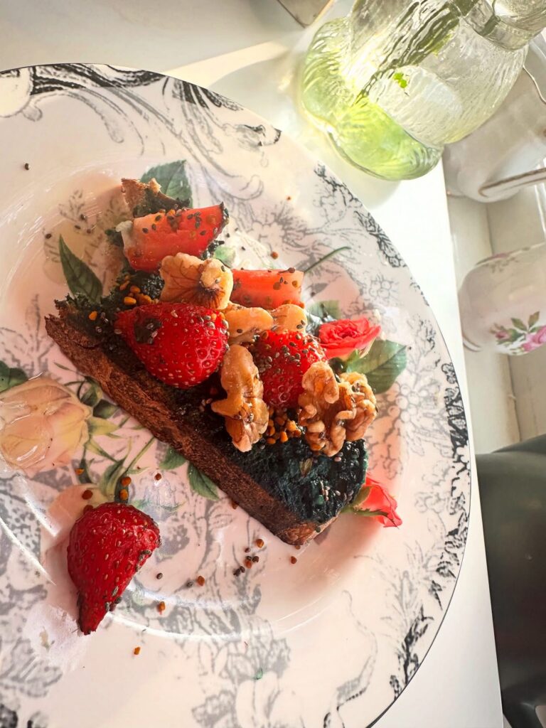 Vegan Blossom Toast topped with berries, nuts and dairy-free spirulina cream cheese at Alchemist Café