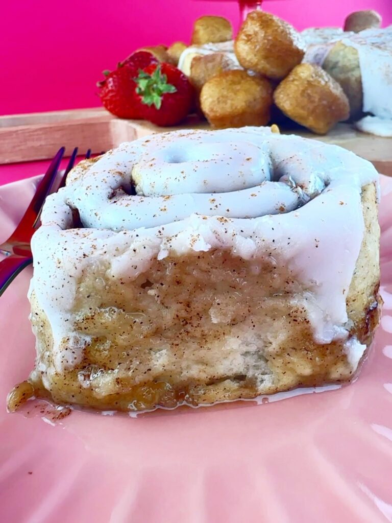 Close-up of a vegan gluten-free cinnamon roll with vanilla icing and cinnamon filling from Gluten Gone Goodies.