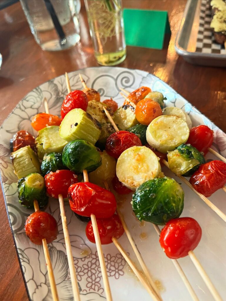 Grilled vegetable skewers with Brussels sprouts, squash, tomatoes, and seasonal vegetables from Honest Acre Farm.