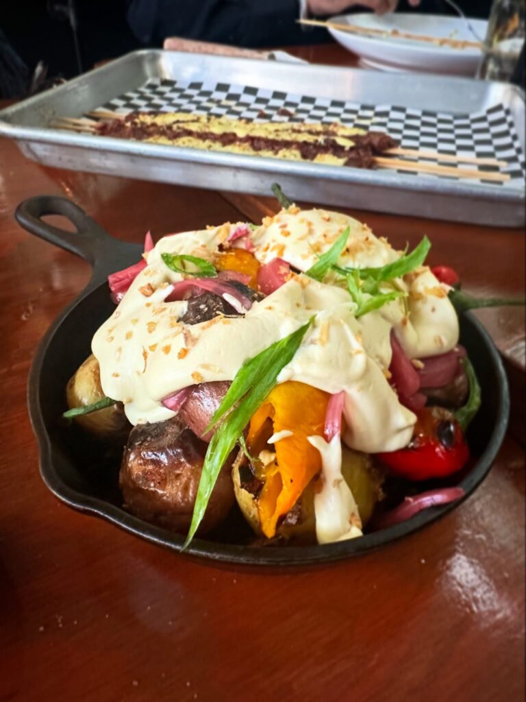 Coal-roasted potatoes topped with creamy almond fondue, Jimmy Nardello peppers, pickled red onions, and crispy garlic.