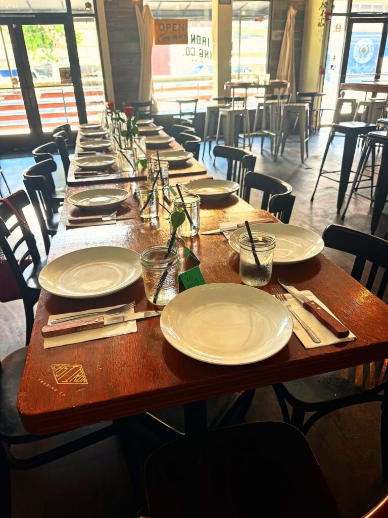 Long communal table set for guests attending the family-style Vegan Roast dinner at Cast Iron Trading Co. in Stockton.