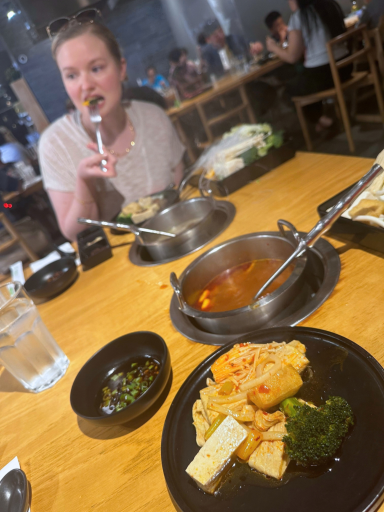 Vegan hot pots with individual soup pots, tofu, vegetables, and dipping sauce at MUMU Hot Pot