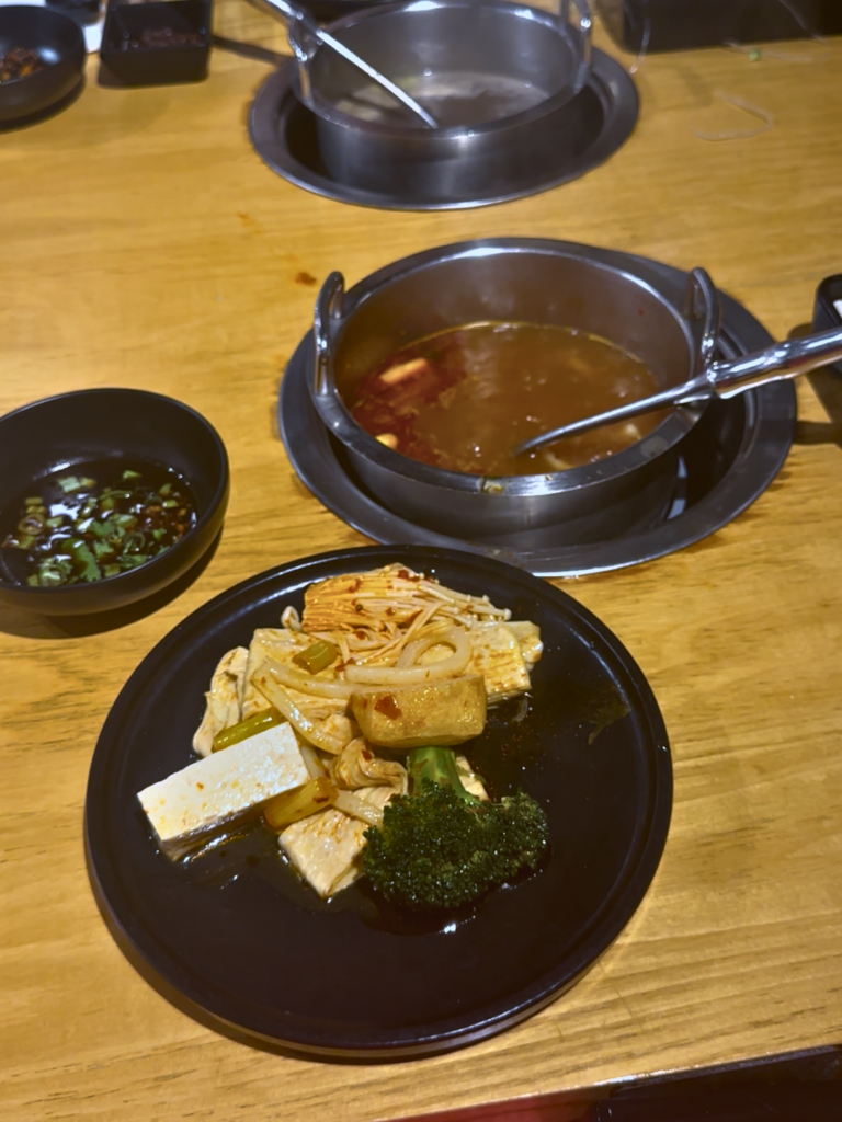 Vegan hot pot tom yum, with tofu, broccoli, fried bean curd rolls and dipping sauce at MUMU Hot Pot
