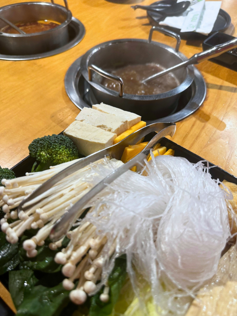 Vegan hot pot with mushroom broth and tofu, vermicelli noodles, enoki mushrooms, broccoli, and vegetables at MUMU Hot Pot