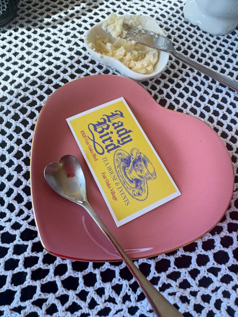 1. Pink heart-shaped plate and Lady Bird Tea House card on a lace-covered tea table.