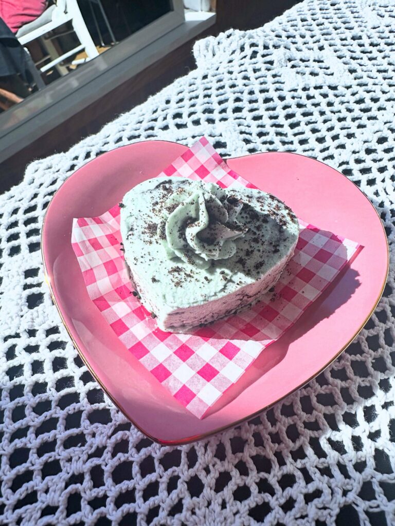 Heart-shaped vegan mint cookies and cream cake served on a pink heart-shaped plate.