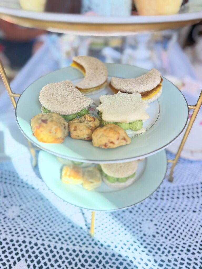 Savory vegan finger sandwiches and bites arranged on a tiered afternoon tea stand.