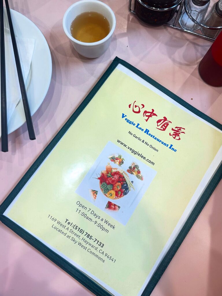 Veggie Lee restaurant menu on a pink dining table with a cup of tea in Hayward, California